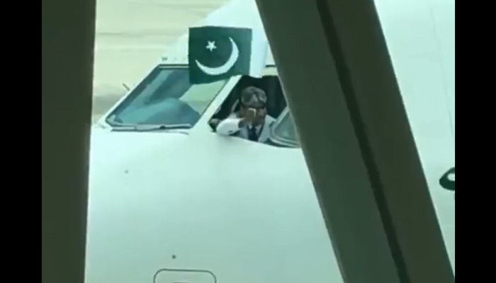 Pilot of inaugural flight to new Islamabad airport holds out Pakistan flag from cockpit window