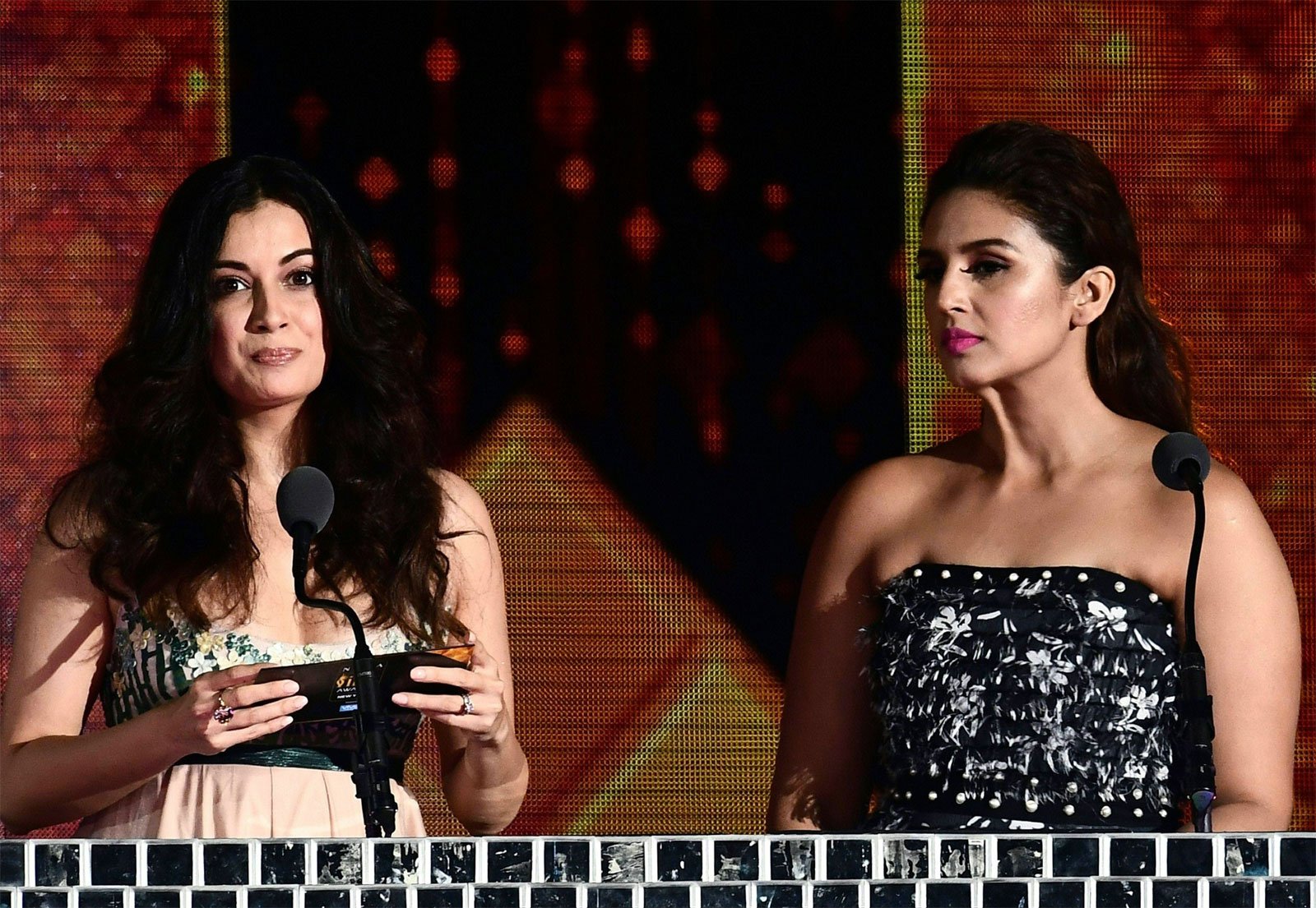 Dia Mirza (L) announces a winner as Huma Qureshi looks on during IIFA Rocks/AFP