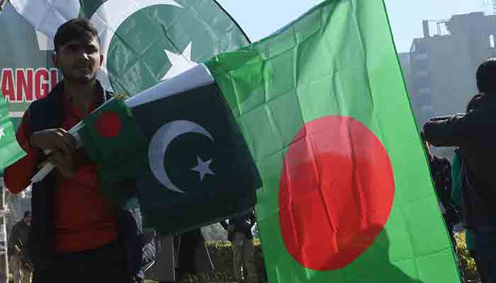 A man holding flags of Pakistan and Bangladesh. File photo