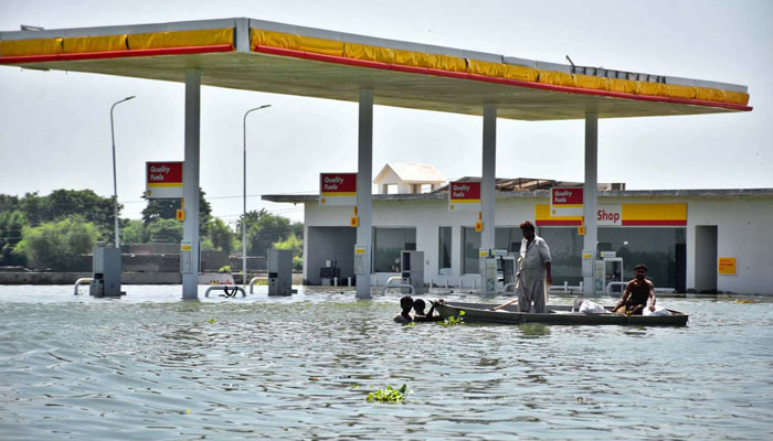 Flood-hit people are going to safer place on boat in Khairpur Nathan Shah on September 3, 2022. APP