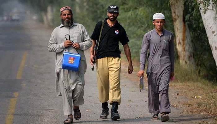 Polio team walking with security guard. —Twitter