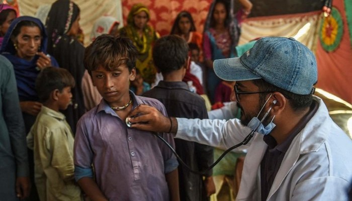 A Pakistani paramedic examines a child at a medical camp in Jamshoro district of Sindh province. - AFP