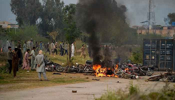 Pakistan´s former Prime Minister Imran Khan´s supporters burn vehicles as they protest outside a court in Islamabad on March 18, 2023. — AFP