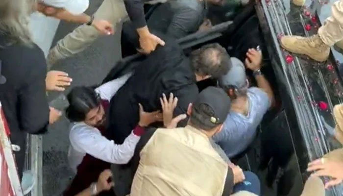 An aerial shot of PTI workers carrying Imran Khan into his car after the attack in Wazirabad on 3 November 2022. —AFP