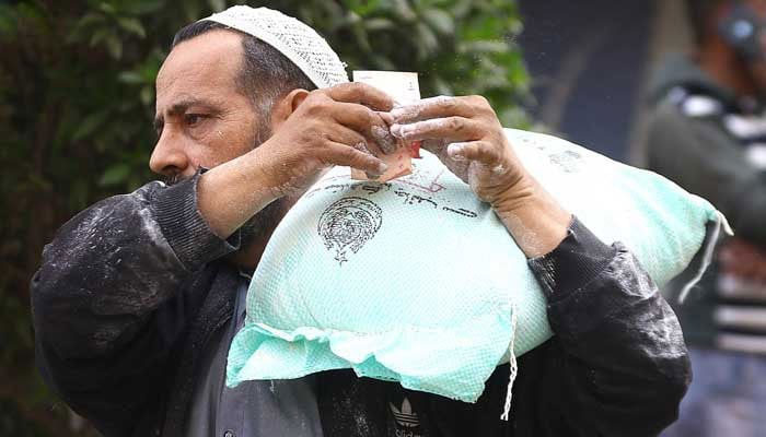 A man carries a government-subsidised flour bag after buying it from a delivery truck in Karachi on January 10, 2023. — INP