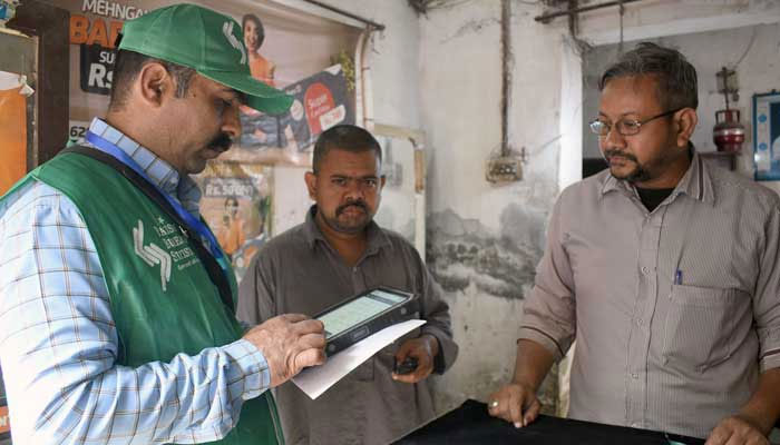 An official from the Pakistan Bureau of Statistics marks a house after collecting information from a resident during population census at Bibi Pak Daman area, in Lahore on March 2, 2023. — Online