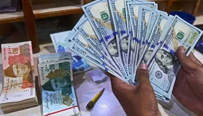 A foreign currency dealer counts US dollars at a shop in Karachi, Pakistan, May 19, 2022. — AFP/ file