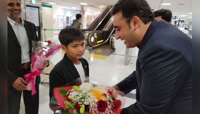 A child presents a bouquet of flowers to the foreign minister at the airport. — Twitter/@ForeignOfficePk