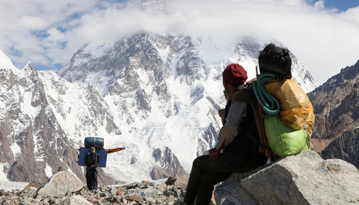 This picture taken on July 15, 2023, shows a Pakistani porter looking towards K2, worlds second tallest mountain in the Karakoram range of Gilgit Baltistan, Pakistan. — AFP