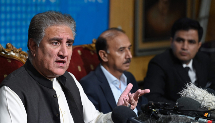 PTI Vice Chairman Shah Mahmood Qureshi (L), speaks as Imran Khans legal spokesperson Naeem Haider Panjutha (R), listens, during a briefing in Islamabad on August 7, 2023. — AFP