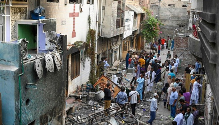 Police and local residents stand amid debris beside Saint John’s church in Jaranwala, outskirts of Faisalabad, Pakistan, Aug. 17, 2023. — AFP