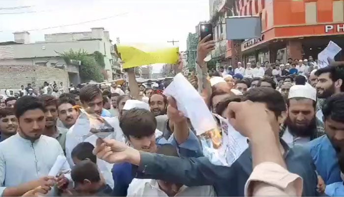 People seen setting their power utility bills on fire in a protest demonstration in Peshawar on August 25, 2023. Screengrab of a Twitter video.