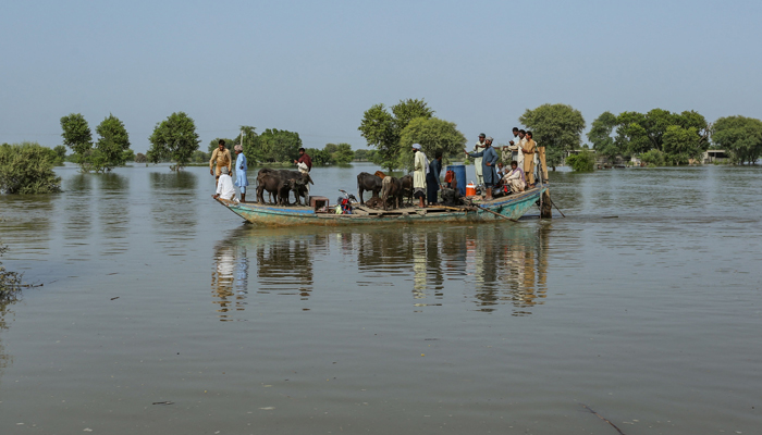 Villagers are evacuated on to boats from a flooded area of Vehari district in Punjab on August 24, 2023. — AFP