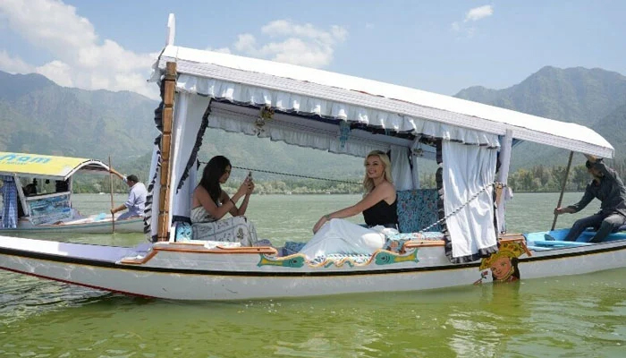 This image shows Miss World 2022 Karolina Bielawska (C) and Miss India World 2022 Sini Shetty (L) riding a boat in the Dal Lake in Srinagar. — AFP