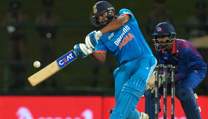 Indias captain Rohit Sharma (L) plays a shot during the Asia Cup 2023 one-day international (ODI) cricket match between India and Nepal at the Pallekele International Cricket Stadium in Kandy on September 4, 2023. — AFP