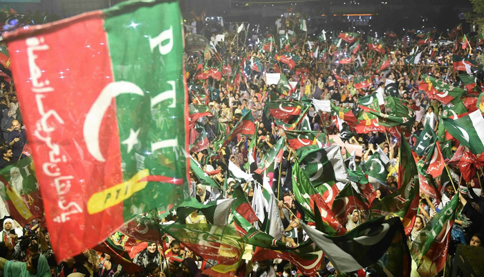 PTI supporters wave party flags as they take part in a rally in Karachi. — AFP/File