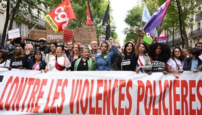 Protesters hold a placard which reads Against police violence during a united march against police brutality called by NGOs, unions and political parties in Paris on September 23, 2023. — AFP