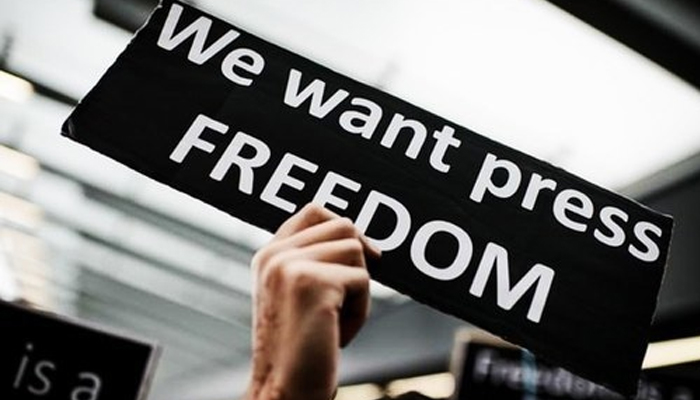 A representational image of a person holding a sign board noted We want press FREEDOM. — AFP/File