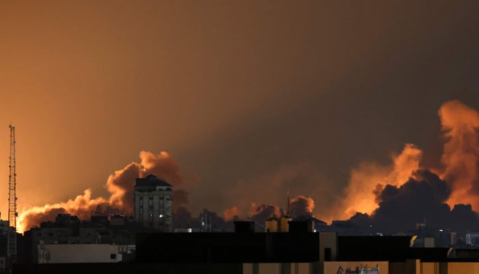 A plume of smoke rises above buildings in Gaza City during an Israeli air strike, on October 8, 2023. — AFP