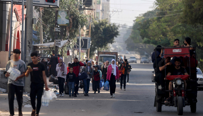 Palestinians carrying their belongings flee to safer areas in Gaza City after Israeli air strikes, on October 13, 2023. — AFP