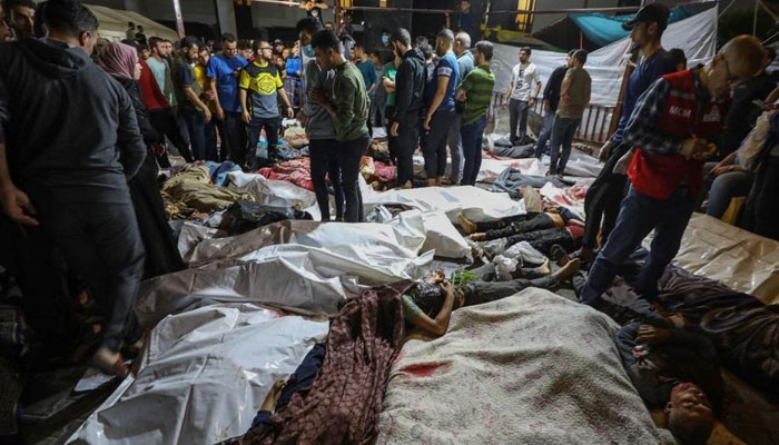 People gather around bodies of Palestinians killed in Israeli airstrikes on the Ahli Arab hospital in central Gaza. Photo: AFP