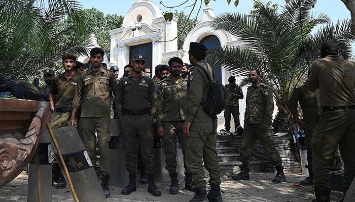 Policemen gather near a street in Lahore on March 16, 2023. — AFP