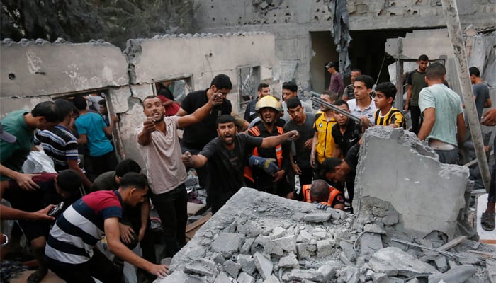 People search for victims and survivors following an Israeli strike on the town of Deir Al-Balah in the central Gaza Strip on October 18 2023. — AFP