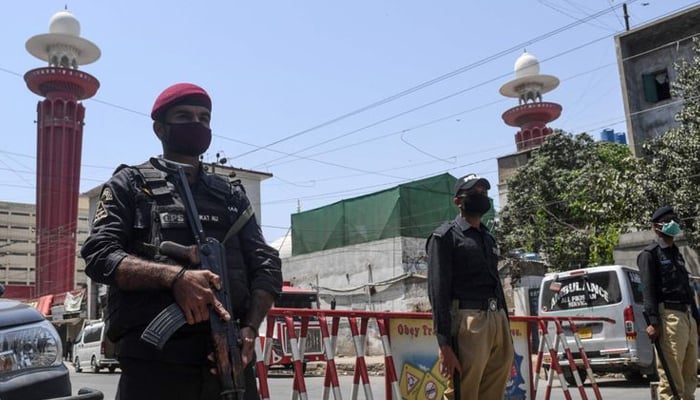 Security personnelstand guard outside a closed mosque in Karachi. — AFP/File