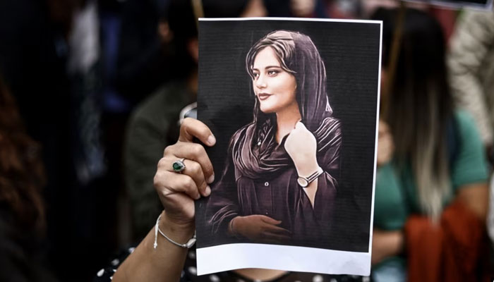 A protester holds a portrait of Mahsa Amini during a demonstration in her support in front of the Iranian embassy in Brussels, Belgium, Sept. 23, 2022, following the death of Amini after her arrest by the countrys morality police in Tehran. AFP