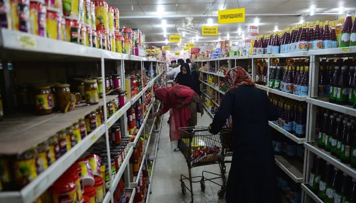 Pakistanis buy food at a utility store (with government-controlled prices) in Islamabad. — AFP/File