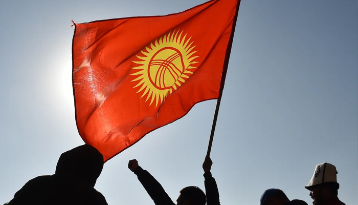 A citizen waves a Kyrgyz flag during a rally in Bishkek, October 14, 2020. — AFP