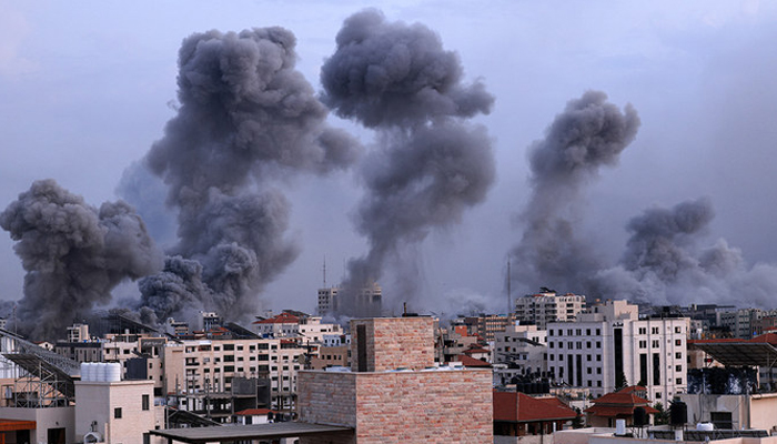 Smoke billows behind highrise buildings during an Israeli airstrike on Gaza City on October 9, 2023. — AFP