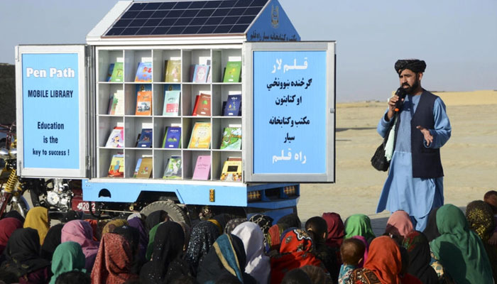 In this photograph taken in 2022, Matiullah Wesa, head of PenPath and advocate for girls education in Afghanistan, speaks to children during a class next to his mobile library in the Spin Boldak district of Kandahar Province. AFP/File