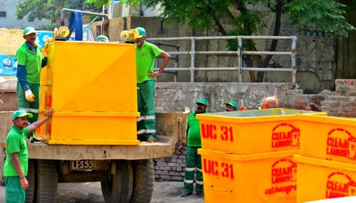 Staff of the Lahore Waste Management Company (LWMC) seen at work. The News Flie