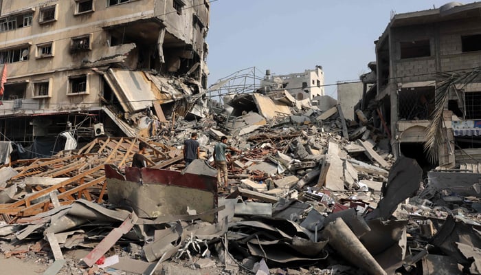 People sift through the rubble of a building destroyed in Israeli strikes on Gaza City on October 28, 2023. — AFP