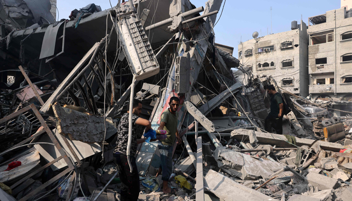 People sift through the rubble of a destroyed building following Israeli strikes on the Al-Shatee camp in Gaza City on October 28, 2023. — AFP