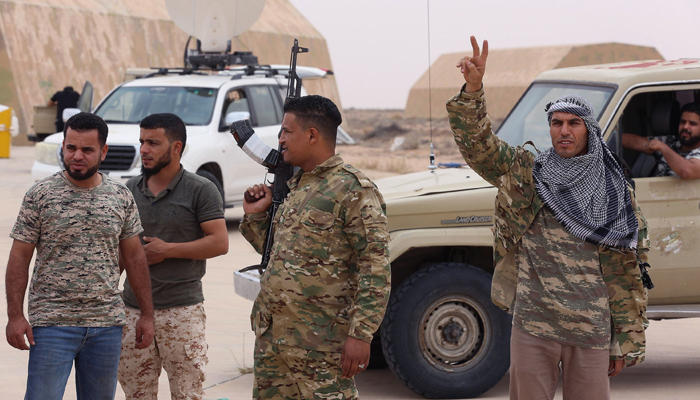 Fighters loyal to Libyas National Accord (GNA) stand outside a hangar at Al-Watiya airbase, which they seized control of, southwest of the capital Tripoli, May 18, 2020. — AFP