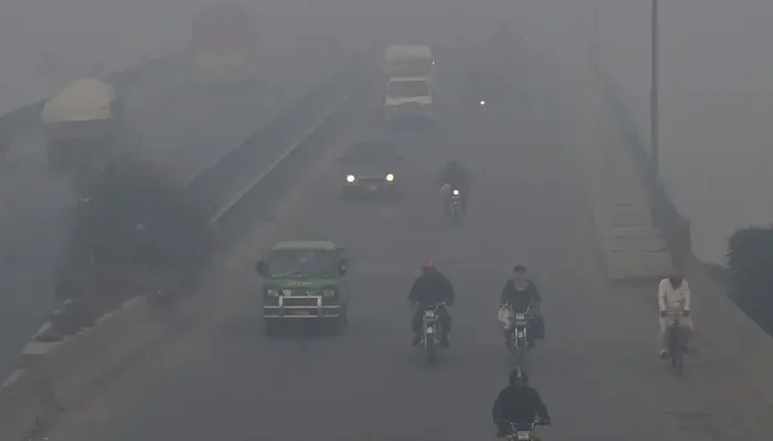 Commuters drive their vehicles through heavy smog in Lahore. — AFP/File