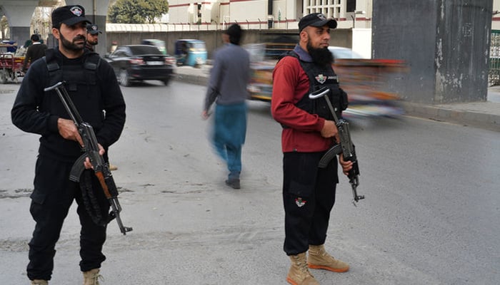 Police perseonnel stand guard in Peshawar. — AFP/File
