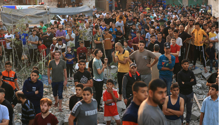 Palestinians look on as rescuers attempt to find survivors and victims from under the rubble following a strike by the Israeli military on Khan Yunis in the southern Gaza Strip on November 4, 2023. — AFP