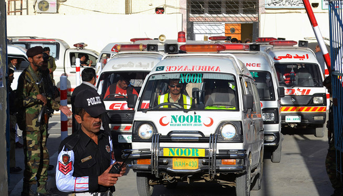 This photo shows Pakistani security personnel standing guard as an ambulance drives past in Quetta. — AFP/File