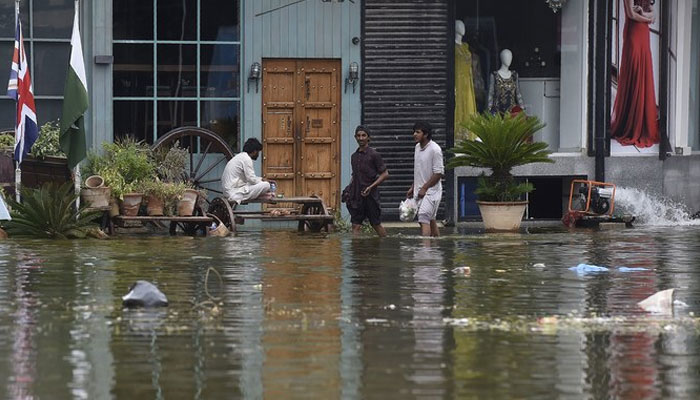 People wade through a flooded residential area following heavy monsoon rains triggered floods in Pakistans port city of Karachi on August 31, 2020. —AFP