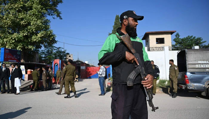 Police officials stand guard outside the Adiala Jail during the hearing of jailed former Pakistan prime minister Imran Khan, in Rawalpindi on October 23, 2023. — AFP