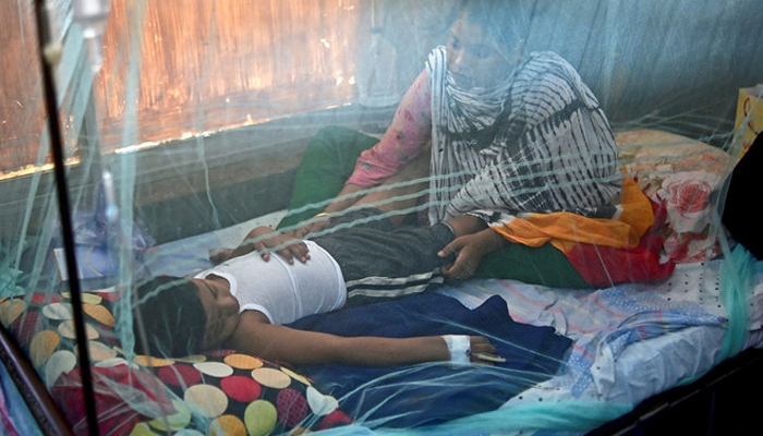 A woman comforts a child suffering from dengue fever at a government hospital. — AFP/File