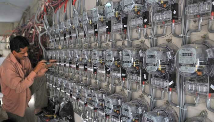 A technician fixes new electricity meters at a residential building in Karachi, Pakistan, in this undated photo. — AFP/File