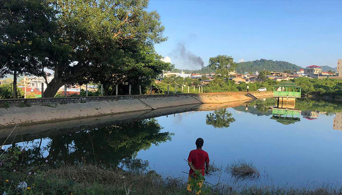 This photo taken Nov. 7, 2023, shows a man watching smoke rising from the direction of a Myanmar military base in Lashio township, northern Shan state. — AFP/File