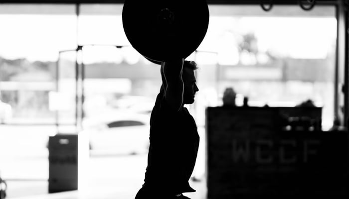 A representational image of a person lifting weight. — Unsplash/File