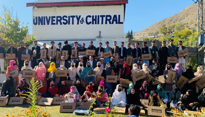 This image released on November 10, 2023, shows a group photo of students after receiving laptops in the University of Chitral. — Facebook/University of Chitral 0fficial