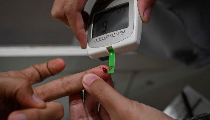 A woman getting her blood sugar level checked. — AFP/File