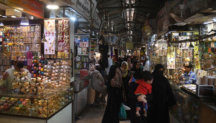 People shop in a market in Karachi. — AFP/File